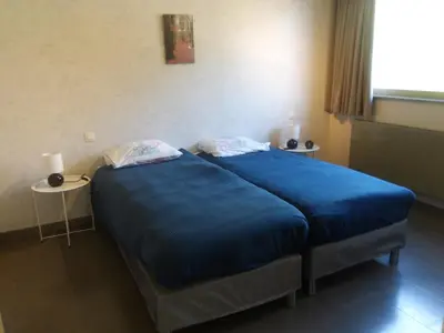 a large blue bed in a room with a window at Meerdaal in Oud-Heverlee