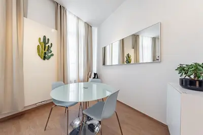 a white dining room with a glass table and chairs at Fully furnished and modern flat - Brussels center in Brussels