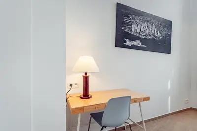 a desk with a lamp and a blue chair at Fully furnished and modern flat - Brussels center in Brussels