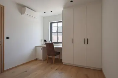 a white room with a desk and a chair at luxurious home in Oud-Turnhout