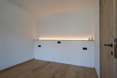 an empty room with a white wall and a wooden floor at luxurious home in Oud-Turnhout