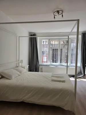 a white bed in a bedroom with a window at Cityhome in Brussels