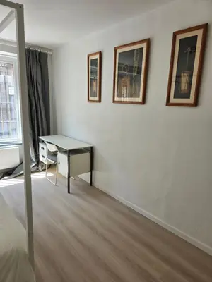 a room with a desk and paintings on the wall at Cityhome in Brussels