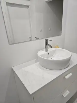 a white bathroom with a sink and a mirror at Cityhome in Brussels