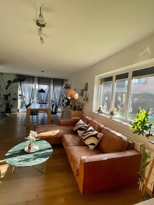 a living room with a brown couch and a table at Lovely house next to Tomorrowland in Boom