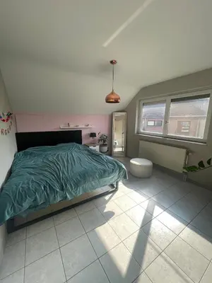 a bedroom with a bed with a green comforter at Lovely house next to Tomorrowland in Boom