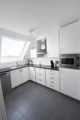 a white kitchen with white cabinets and a window at Tomorrowland 2026 Rooftop-Fireworks View in Boom
