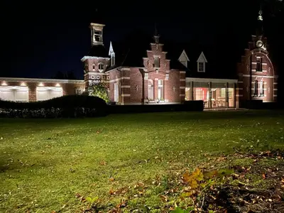 a large building with a lawn in front of it at night at Villa Gentbos - currently 15beds 3bathrooms - from june 2026 up to 21beds 6bathrooms in Pataterhoek