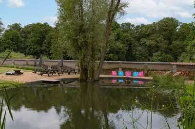 a park with a tree and a picnic table next to a pond at Villa Gentbos - currently 15beds 3bathrooms - from june 2026 up to 21beds 6bathrooms in Pataterhoek
