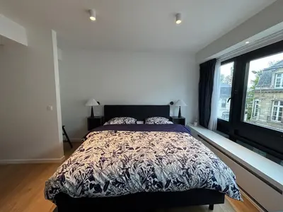 a bedroom with a bed and a large window at Studio Vleurgat in Brussels