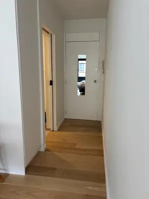 an empty hallway with white walls and wood floors at Studio Vleurgat in Brussels