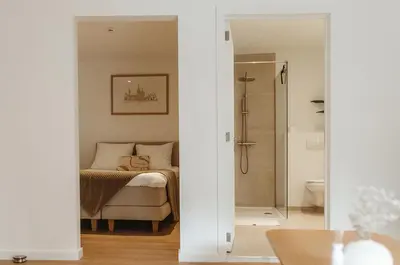 a bedroom with a bed and a walk in shower at Studio&Stay Room in Ghent