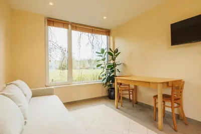 a living room with a table and a window at B&B Zoersel in Zoersel