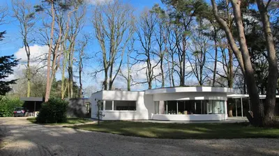 a white house in the middle of trees at B&B Zoersel in Zoersel