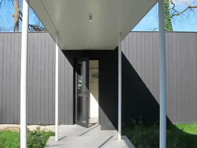 a building with a white roof and a doorway at B&B Zoersel in Zoersel
