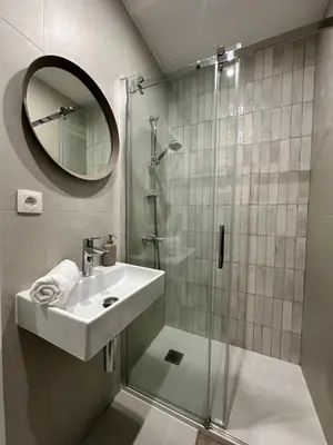 a bathroom with a sink and a shower with a mirror at New studio centre in Brussels
