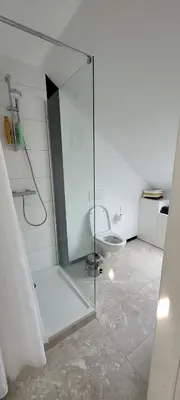 a bathroom with a glass shower with a toilet at DokAttic50 in Ghent