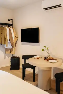 a room with a table and a tv on a wall at Raibu Antwerp by StayC in Antwerp