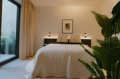 a bedroom with a bed and a potted plant at Raibu Antwerp by StayC in Antwerp
