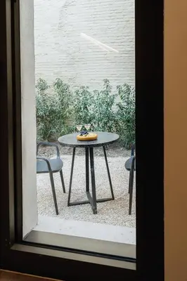 a table and chairs sitting outside a window at Raibu Antwerp by StayC in Antwerp