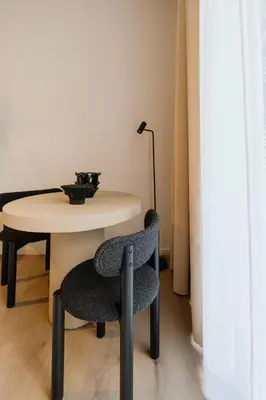 a chair sitting next to a table with a lamp at Raibu Antwerp by StayC in Antwerp