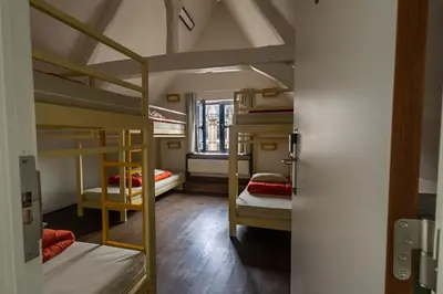 a room with four bunk beds and a doorway at Hostel Uppelink in Ghent