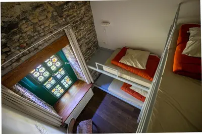 a small room with two beds and a window at Hostel Uppelink in Ghent