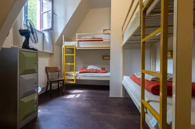 a room with two bunk beds and a staircase at Hostel Uppelink in Ghent