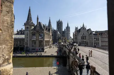 a bridge over a river in a city with buildings at Hostel Uppelink in Ghent