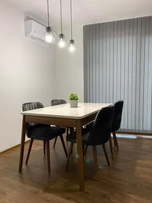 a dining room table with black chairs and a white wall at Merjay Garden Residence in Brussels