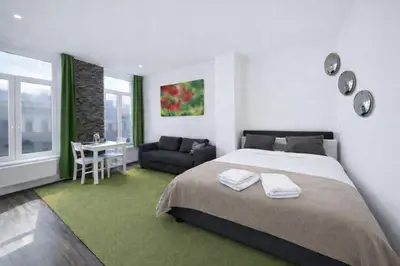 a bedroom with a bed and a table and a couch at Spacious and Chic 1BR - Separate Kitchen & Washer in Brussels