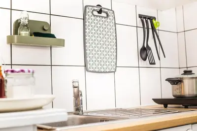 a kitchen with a sink and a stove with utensils at Spacious and Chic 1BR - Separate Kitchen & Washer in Brussels