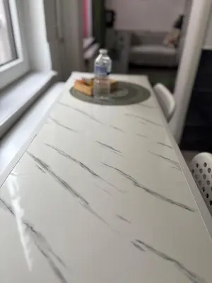 a table with a bottle of water on top of it at Spacious and Chic 1BR - Separate Kitchen & Washer in Brussels