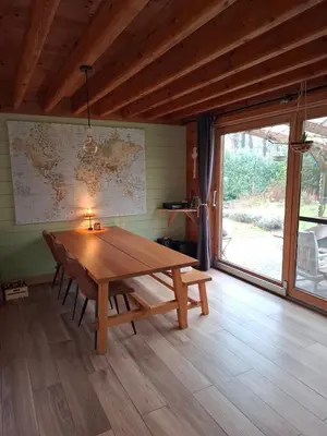 a wooden table in a room with a large window at Innersoulhouse in Wuustwezel