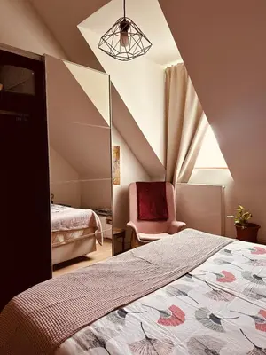 a bedroom with a bed and a mirror and a chair at Luxurious stay with zen atmosphere in Zurenborg in Antwerp