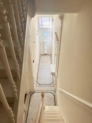 a hallway with stairs leading up to a door at Luxurious stay with zen atmosphere in Zurenborg in Antwerp