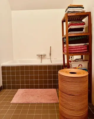 a bathroom with a tub and a stack of towels at Luxurious stay with zen atmosphere in Zurenborg in Antwerp