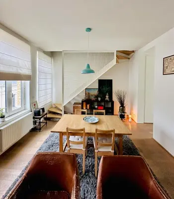 a living room with a wooden table and chairs at Luxurious stay with zen atmosphere in Zurenborg in Antwerp