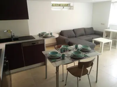 a kitchen and a living room with a table and a couch at relaxation in Waterloo, 2 steps from the center of Brussels in Waterloo