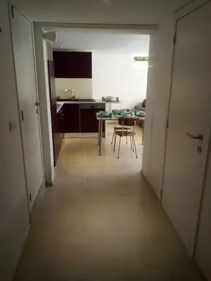 a hallway leading to a kitchen with a table and chairs at relaxation in Waterloo, 2 steps from the center of Brussels in Waterloo