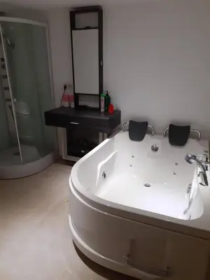 a white bath tub in a bathroom with a mirror at relaxation in Waterloo, 2 steps from the center of Brussels in Waterloo