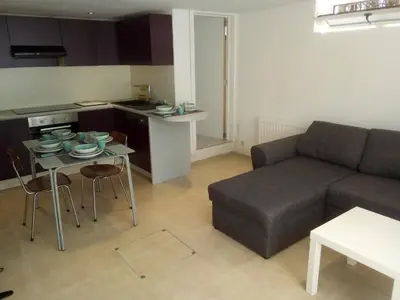 a living room with a couch and a table and a kitchen at relaxation in Waterloo, 2 steps from the center of Brussels in Waterloo