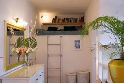 a room with a bunk bed and a desk and plants at The Golden Hour Loft in Brussels