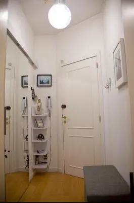 a white room with a door and a shelf with shoes at The Golden Hour Loft in Brussels