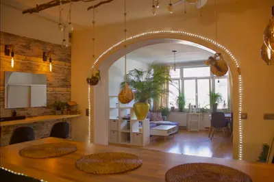 an archway in a room with a table and a living room at The Golden Hour Loft in Brussels