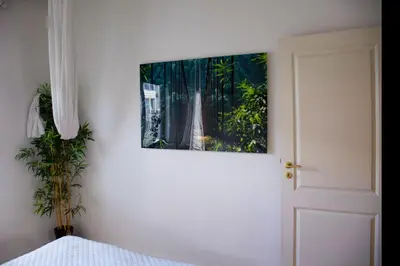 a bedroom with a painting on the wall next to a bed at The Golden Hour Loft in Brussels