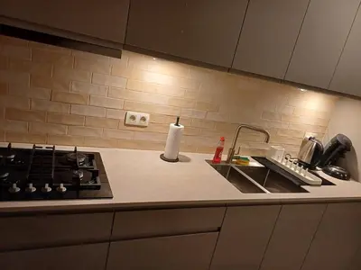 a kitchen counter with a stove and a sink at Cosy -confort appartment in Antwerp