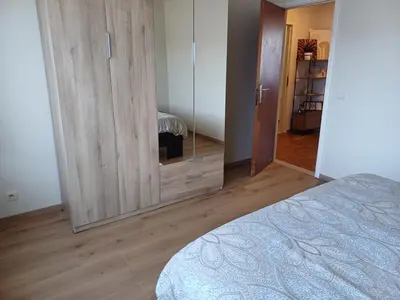 a bedroom with a large wooden cabinet and a bed at Cosy -confort appartment in Antwerp