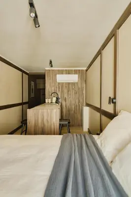 a bedroom with a large bed and a desk at Raibu Ghent by StayC in Ghent