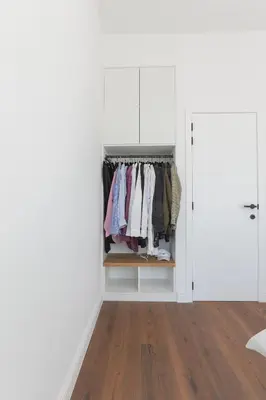 a walk in closet with white walls and wood floors at Southside Suites in Antwerp